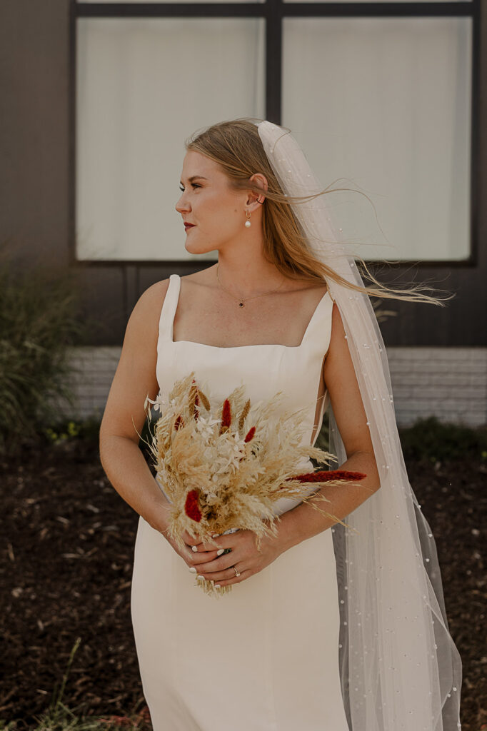 bride holding boho pampas bridal bouquet and smiling