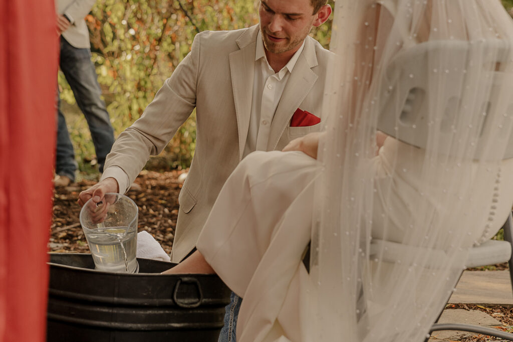 bride and groom washing each others feet christ centered wedding ceremony