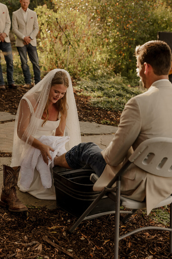 bride and groom washing each others feet christ centered wedding ceremony