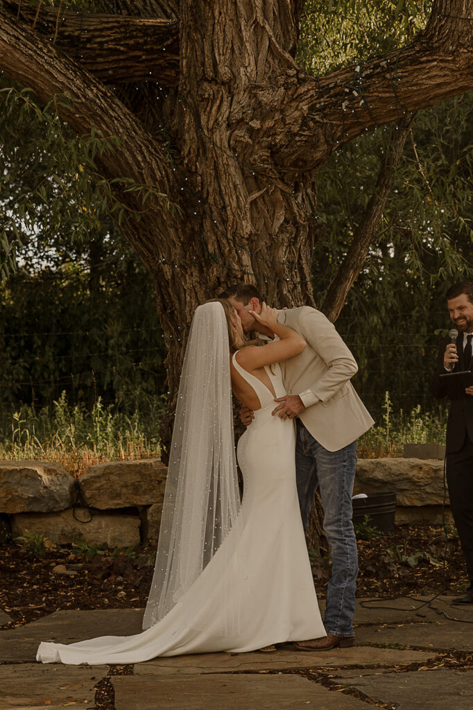 bride and groom kissing during wedding ceremony