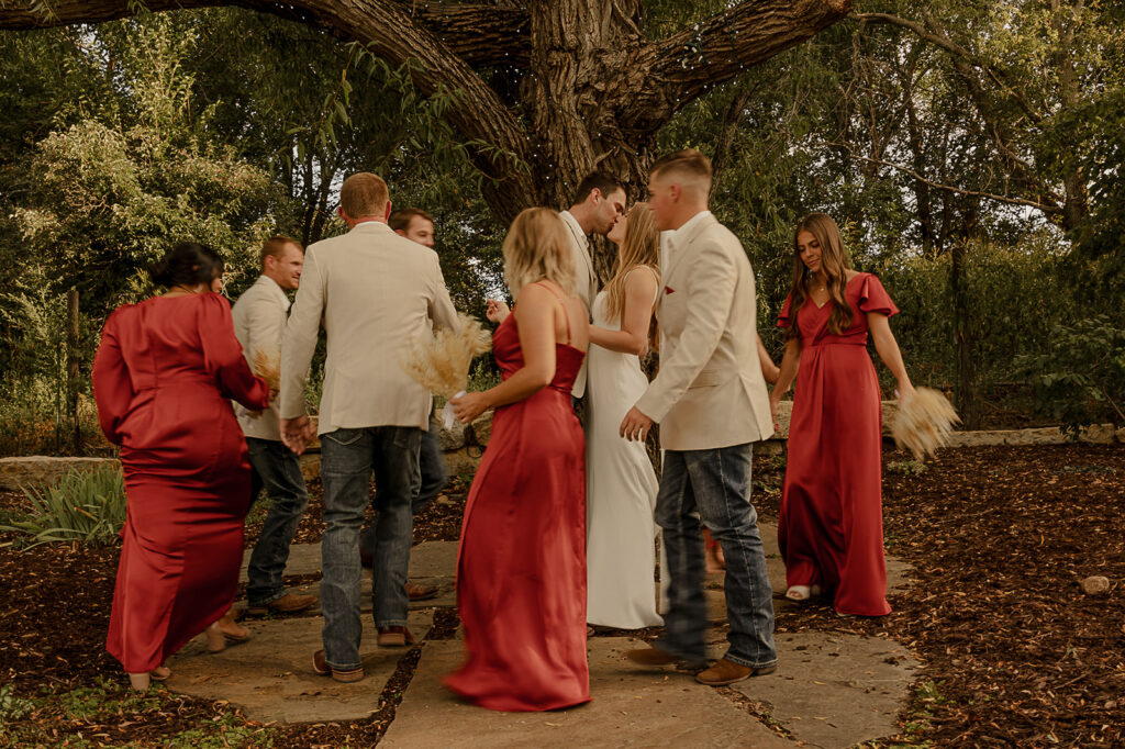 blurry bridal party photos with bride and groom kissing in the middle