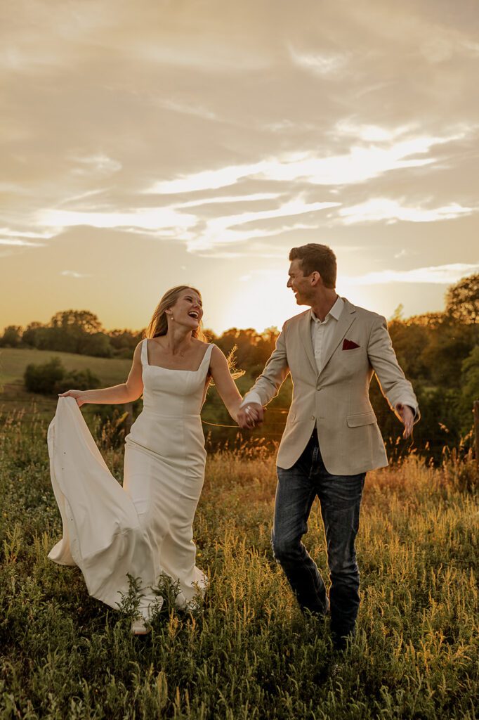 bride and groom holding hands and running in a field iowa wedding photographer