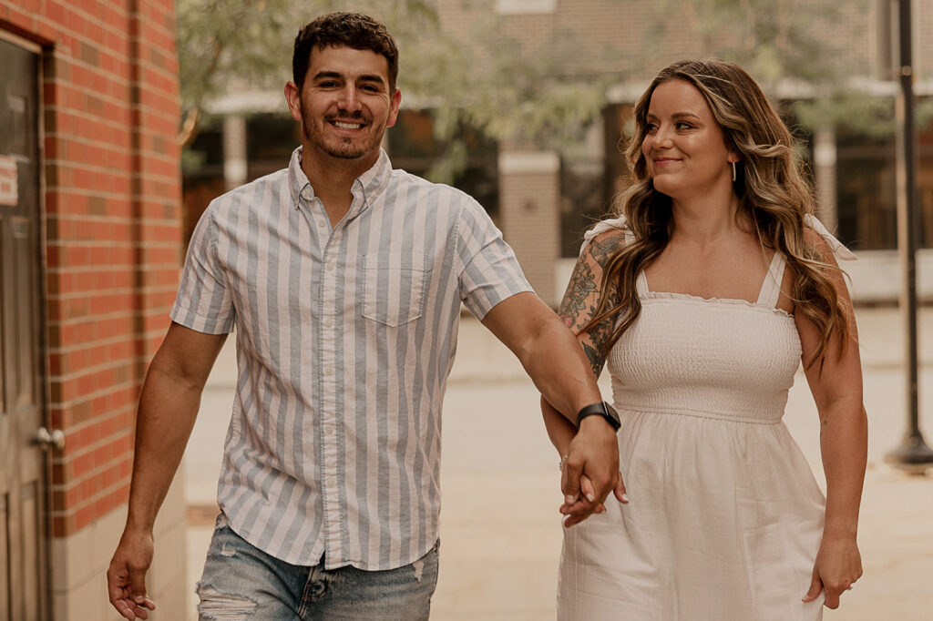 couple smiling and holding hands engagement photos fun