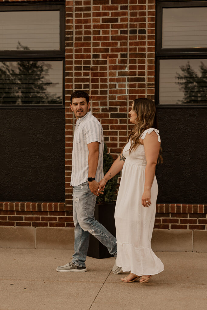 couple holding hands and walking in ames iowa