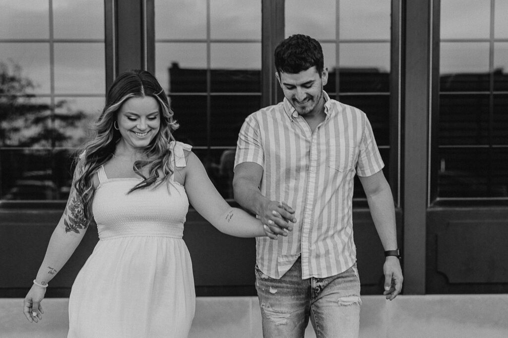 couple holding hands and laughing candid engagement poses