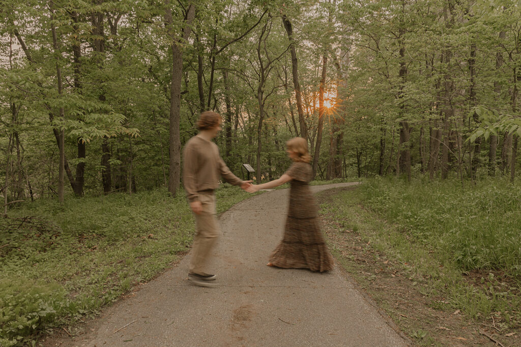 blurry candid engagement photo poses waking on a trail