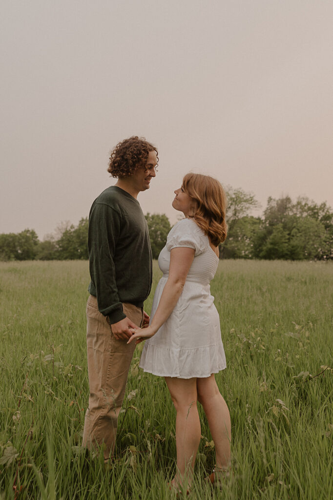 documentary style engagement photos in a field in iowa