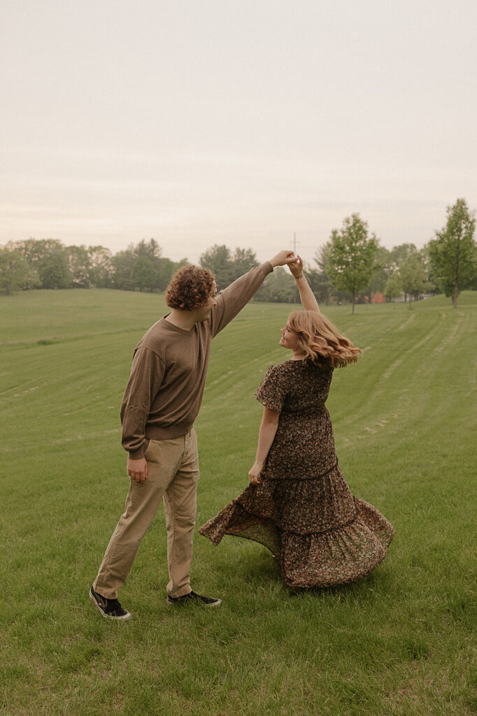 couple spinning and dancing in a field