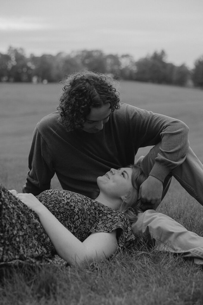 couple sitting in a field in iowa during engagement session