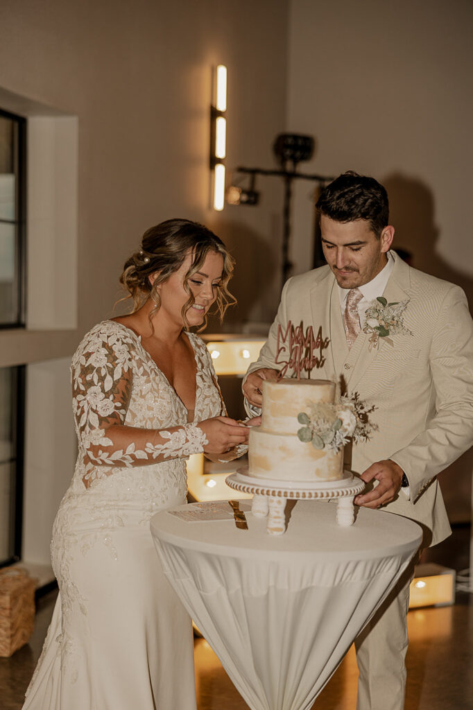 bride and groom cutting the cake and feeding it to each other