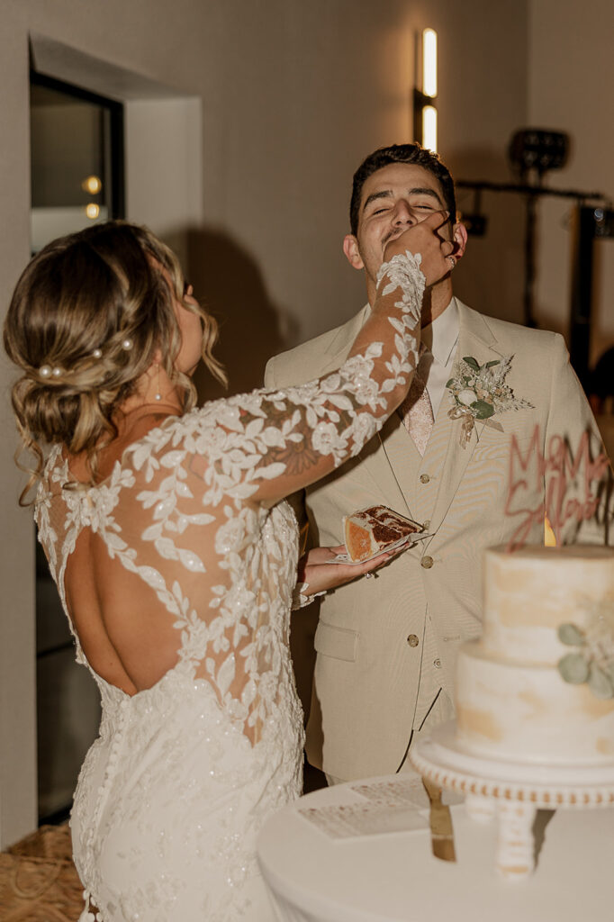 bride and groom cutting the cake and feeding it to each other