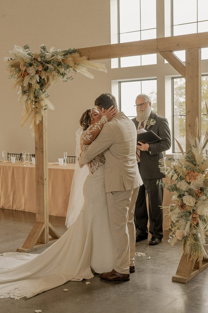 bride and groom kiss during wedding ceremony