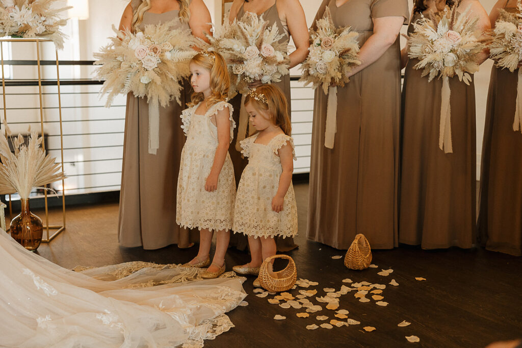 flower girls standing next to bride during ceremony