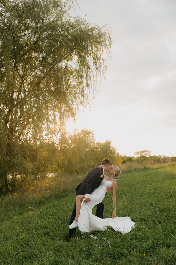 couple photos in front of willow tree during sunset after wedding ceremony