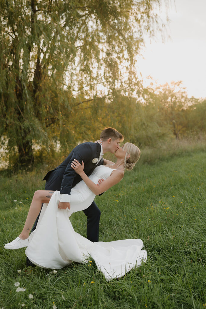 couple photos in front of willow tree during sunset after wedding ceremony