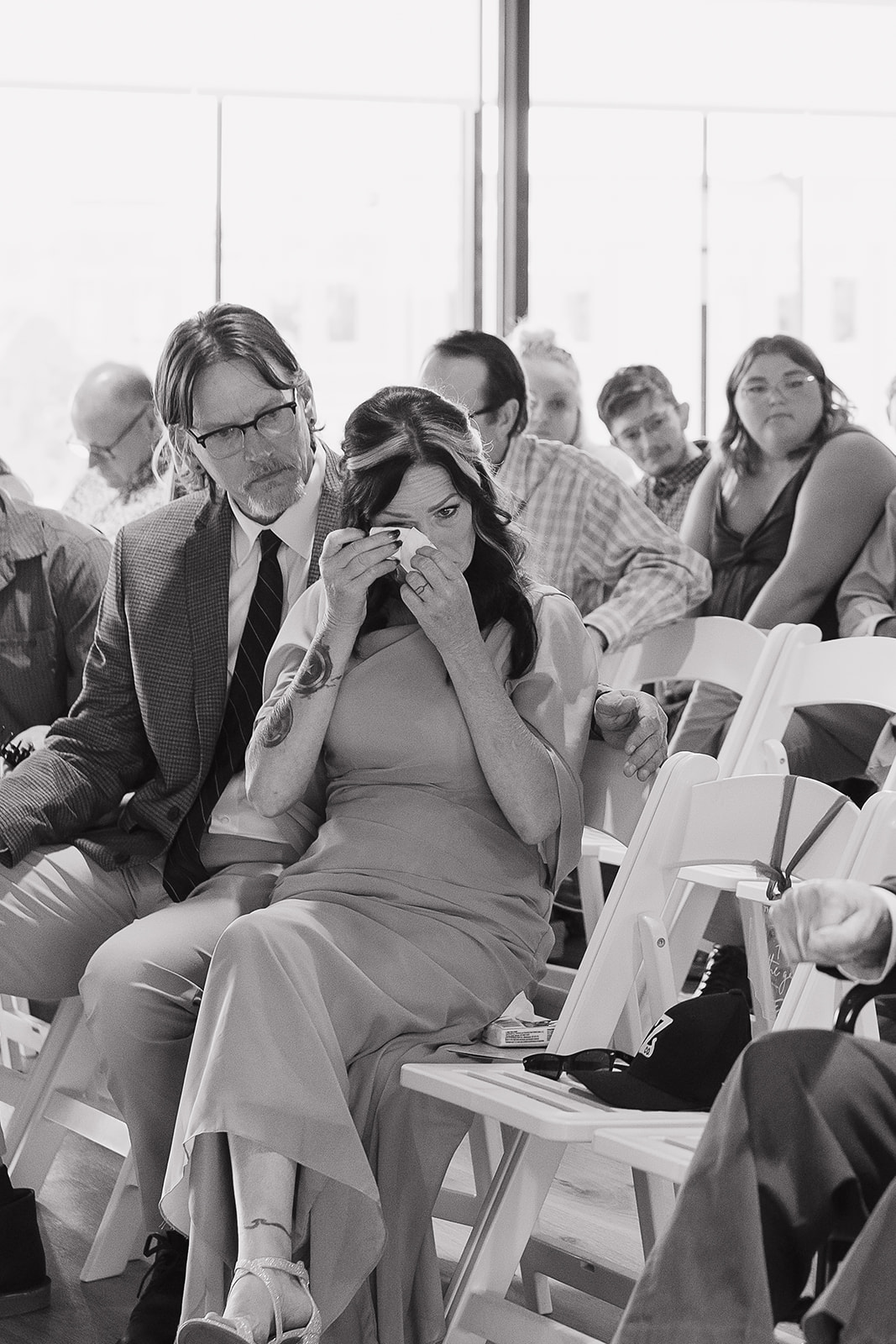 Guest wiping away tears during the ceremony, an emotional moment beautifully documented through documentary wedding photography
