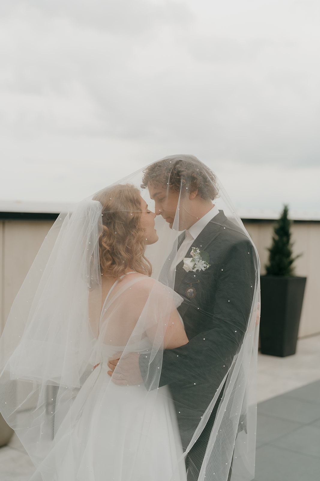 Bride and groom touching noses as they smile softly at each other during their documentary wedding photography portraits.