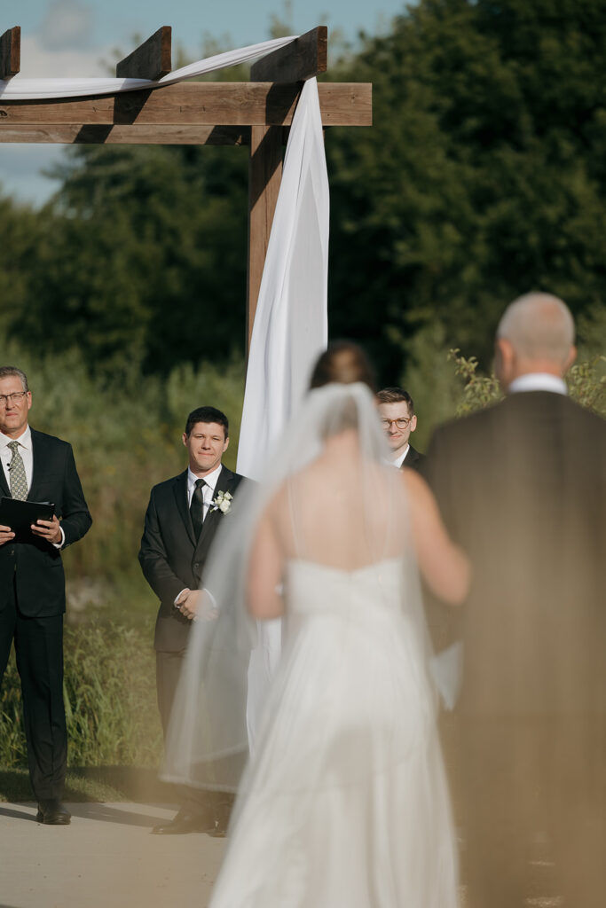 The bride and her dad walking down the aisle to her soon to be husband.