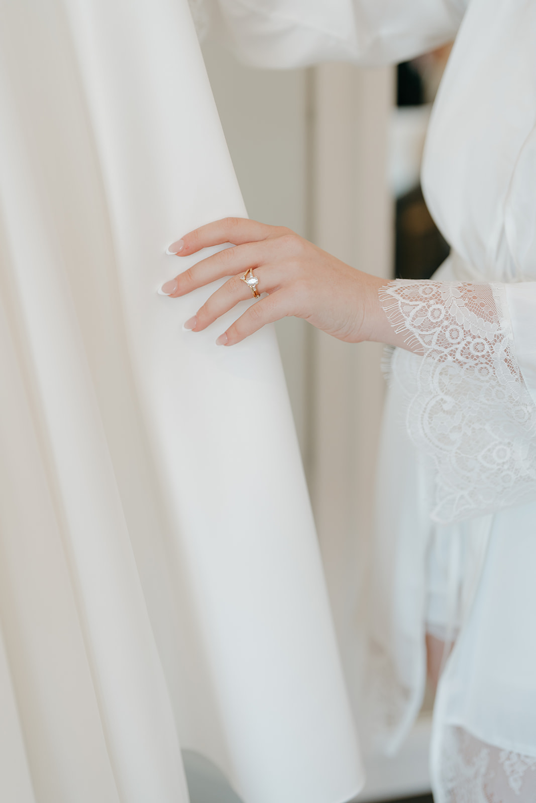 A detail photo of the bride touching her dress before she gets ready.