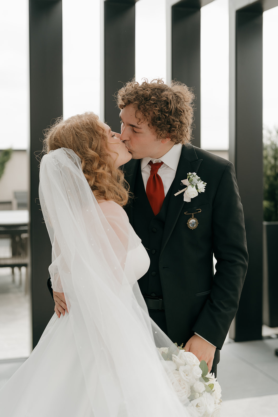 The bride and groom sharing a kiss outside during their bride and groom portraits.