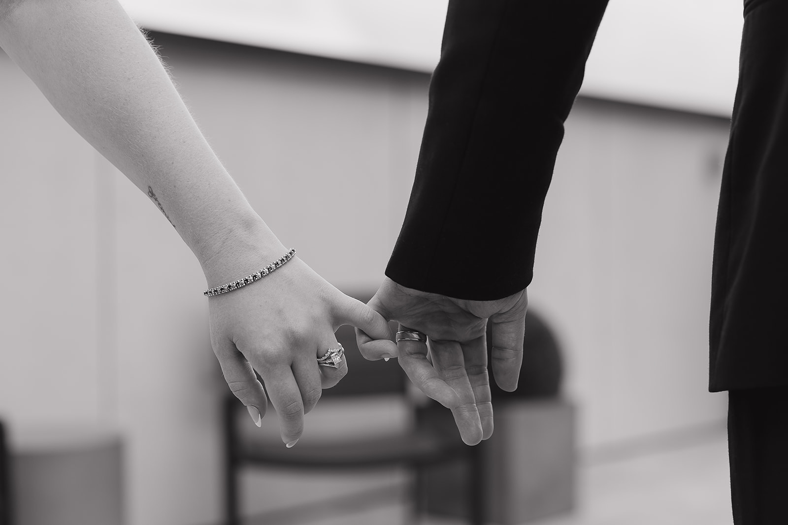 A close up shot of the bride and groom with interlocked pinkies. Captured by a Des Moines Wedding Photographer