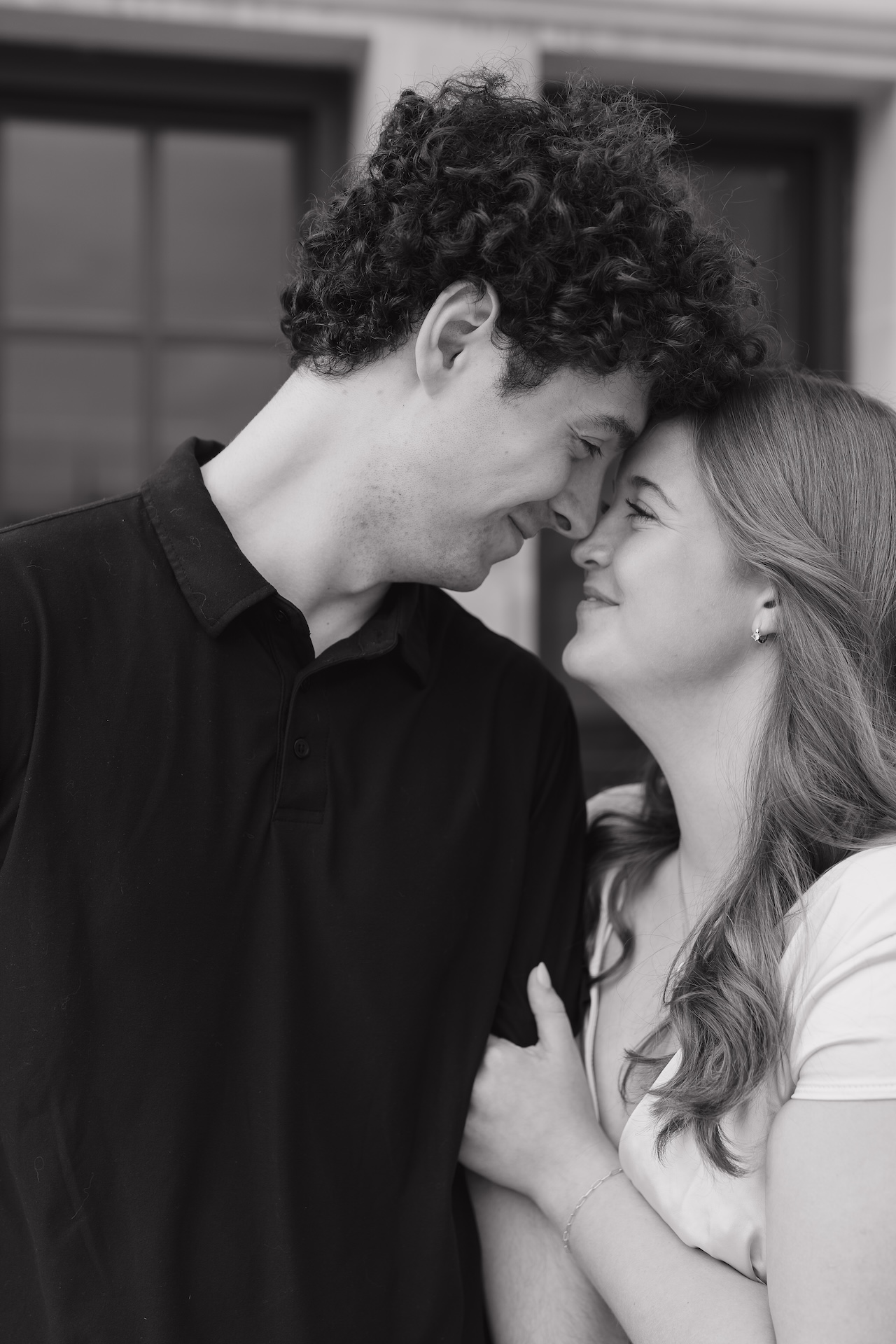 Close-up black and white photo of a couple leaning forehead to forehead, showcasing intimate connection at one of their favorite Engagement Photo Locations.