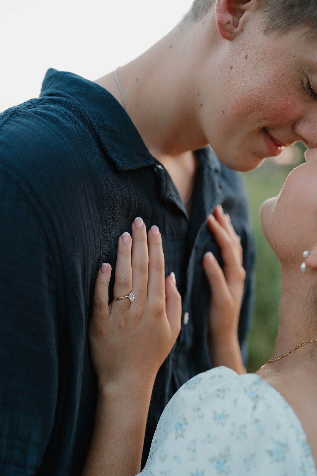 Close up of engagement ring as bride rests her hands on her partner’s chest, intimate documentary engagement photos detail