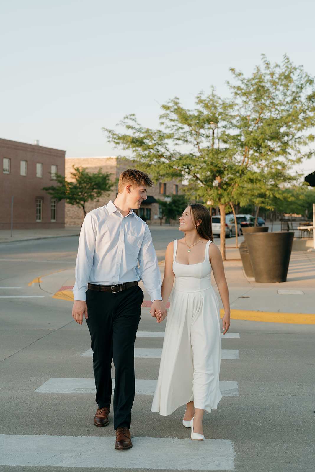 Stylish downtown engagement photo of a couple embracing against a modern architectural backdrop, showcasing an urban setting as one of the most Unique Engagement Photo Locations.