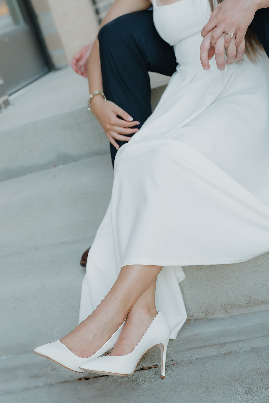 Close-up engagement detail photo of the bride’s ring, dress, and heels on city steps, highlighting styling within Unique Engagement Photo Locations.