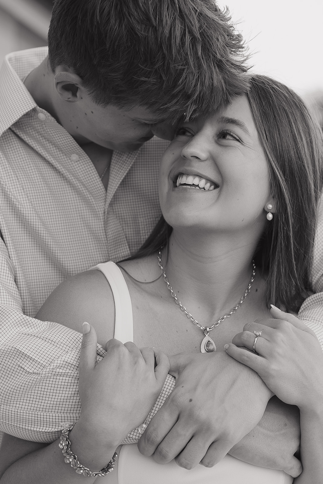 Close up black and white image of couple smiling forehead to forehead, emotional engagement moment