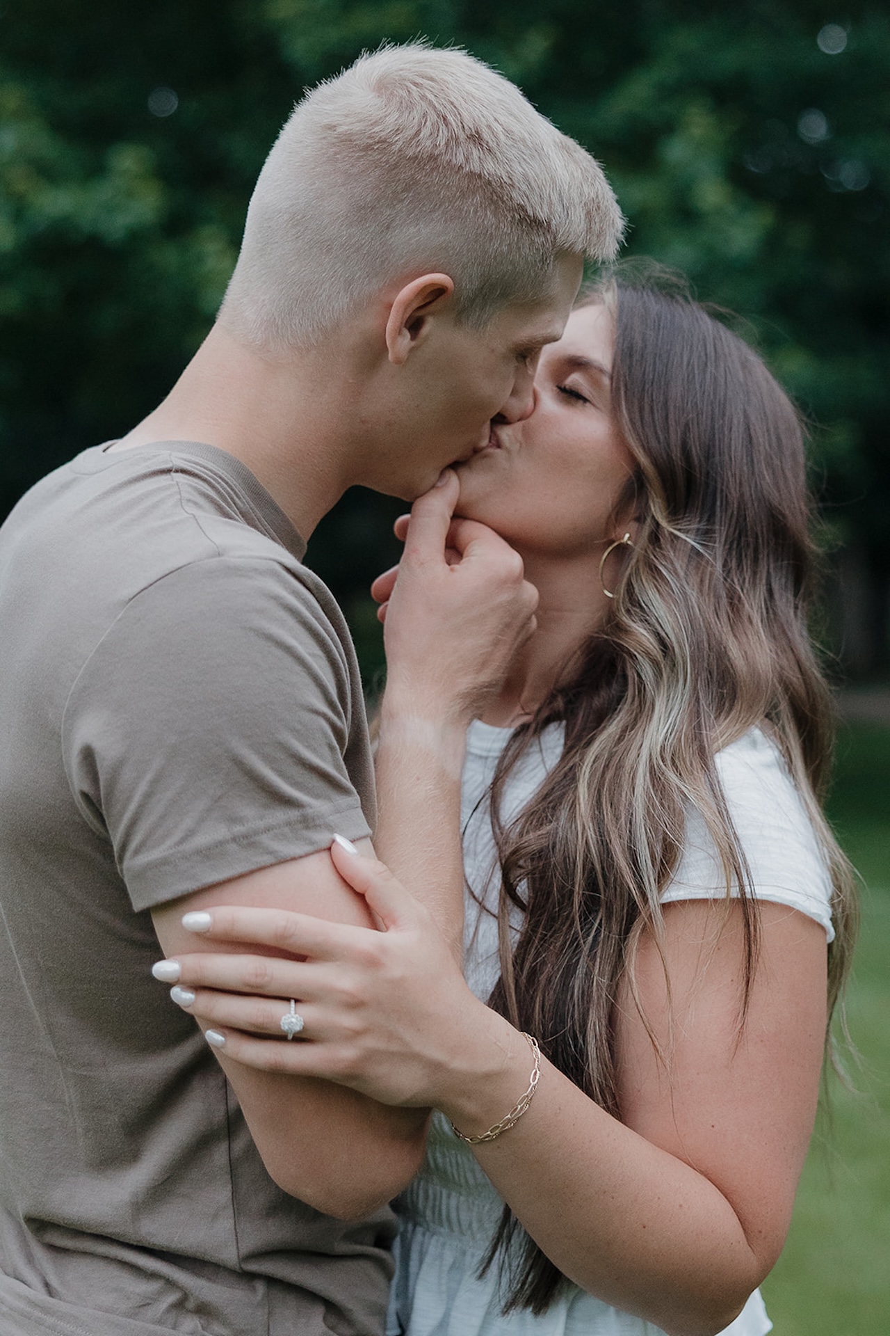 A close-up of an engaged couple sharing a tender kiss outdoors — the kind of shot that makes you want to take engagement photos right now