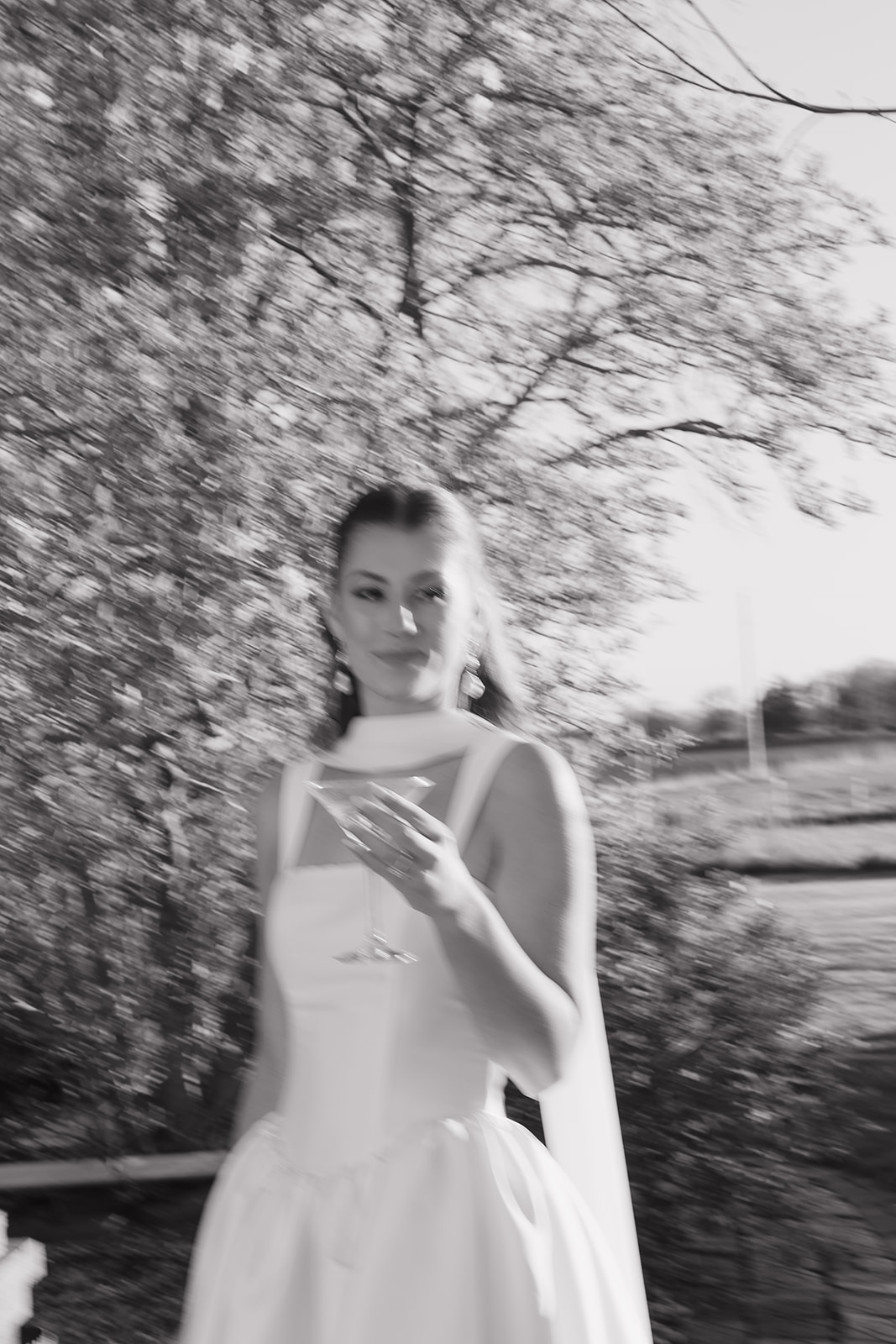 Bride holding a martini glass in black and white, old money wedding aesthetic.
