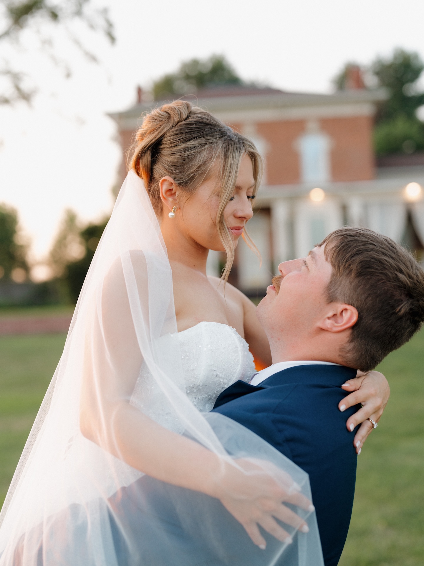 Bride and groom kissing among wildflowers and black-eyed susans at golden hour.